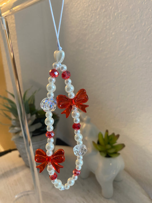 Cell phone charm with red bow ties