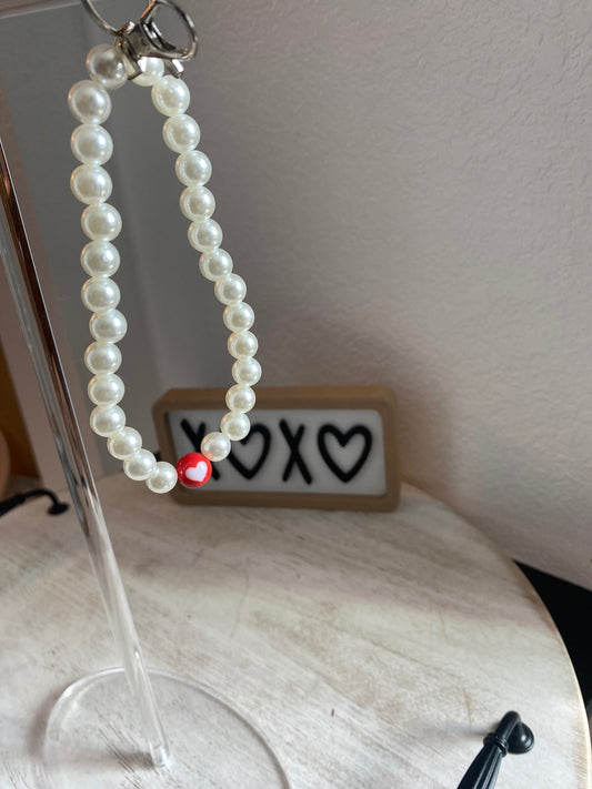 Pearl keychain with red heart.